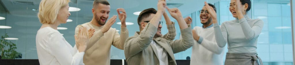 Diverse business team celebrating a win together in a modern office