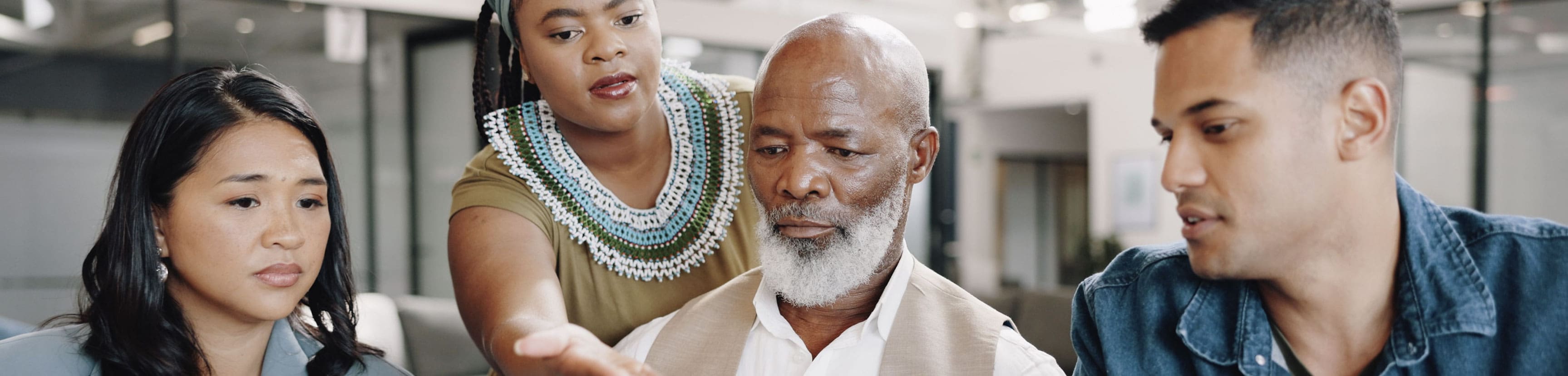 Diverse leadership team representing multiple generations collaborating in a modern office