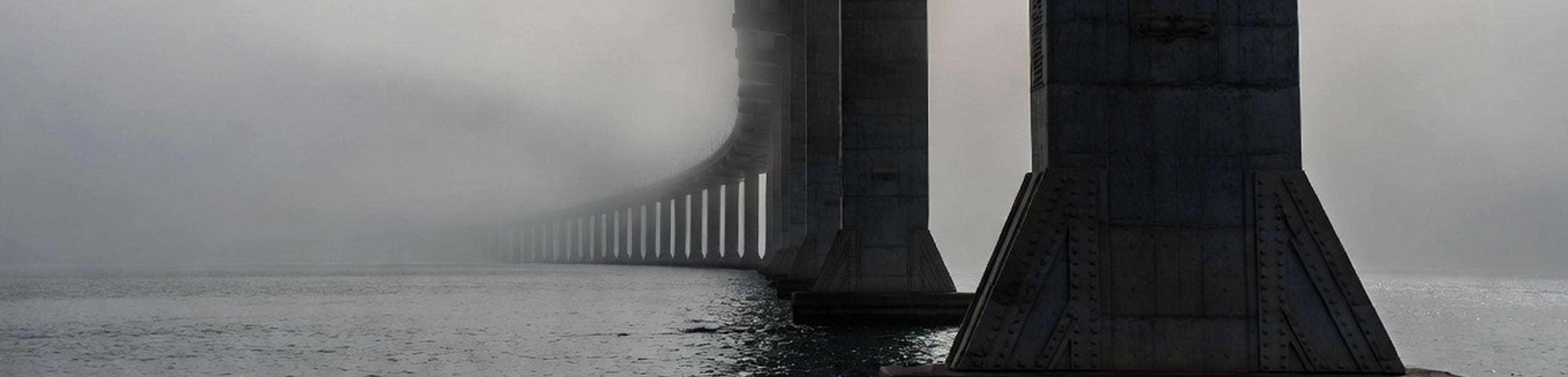 Bridge support pillars receding into fog, illustrating distributed structural support